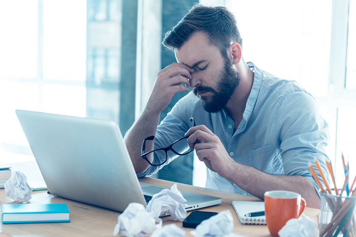 Je me sens &eacute;puis&eacute;. Un jeune homme de barbe frustr&eacute; massant le nez et gardant les yeux ferm&eacute;s alors qu'il &eacute;tait assis &agrave; son bureau