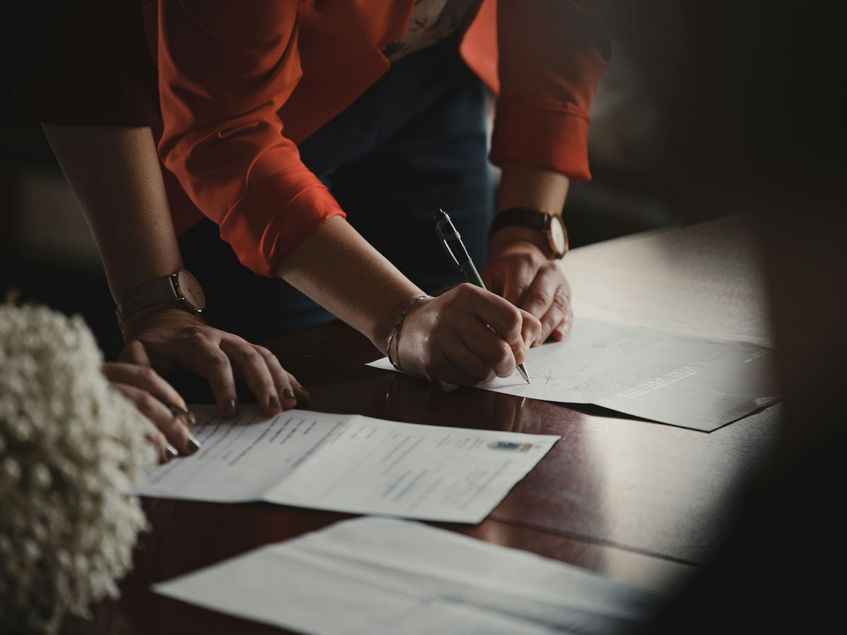 Une personne qui est en train de signer un contrat avec un tiers