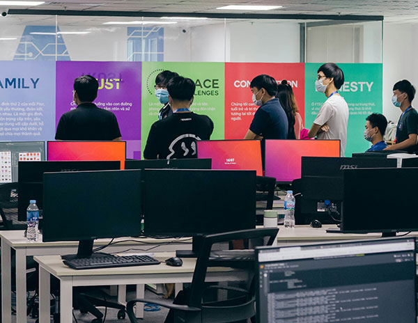 Des employ&eacute;s devant un mur d'affiches consacr&eacute; &agrave; la pr&eacute;vention au travail. 