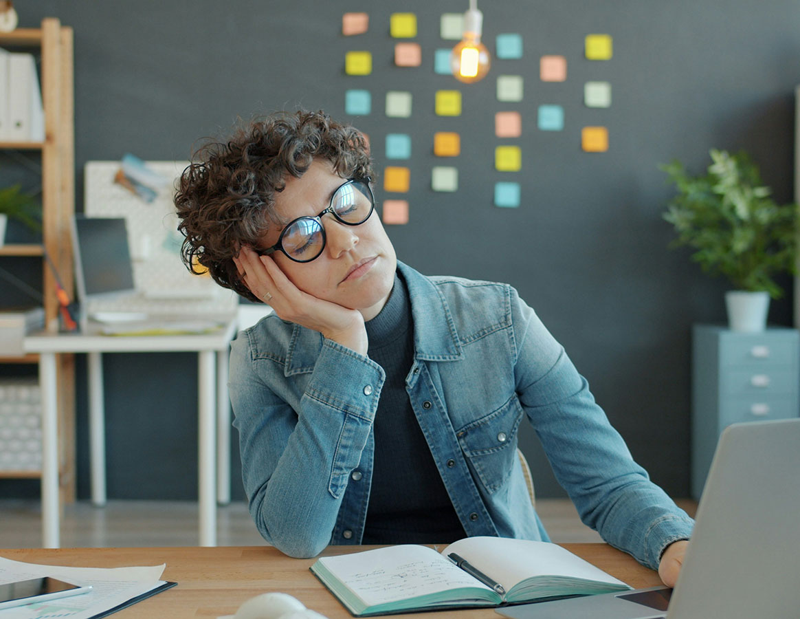 Une femme devant son bureau, les yeux ferm&eacute;s