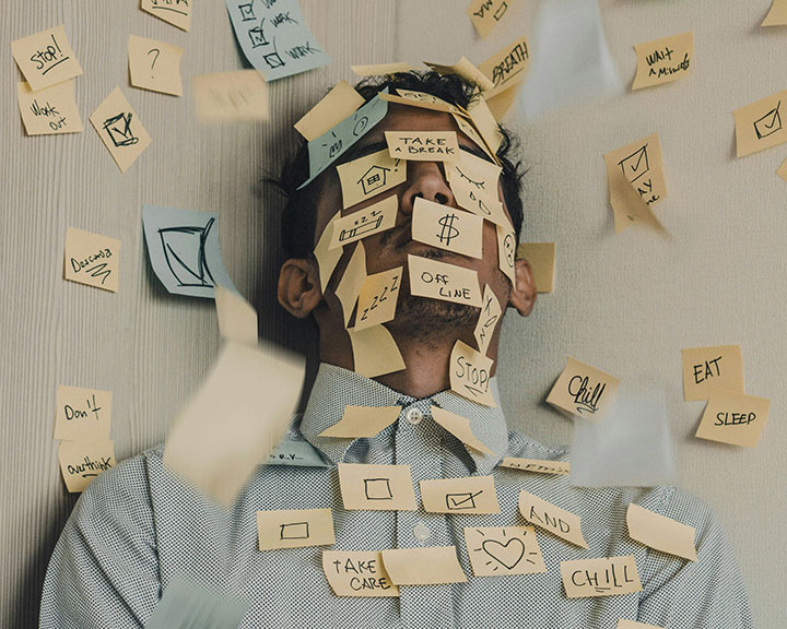 Un homme par terre avec plein de post-it sur la t&ecirc;te