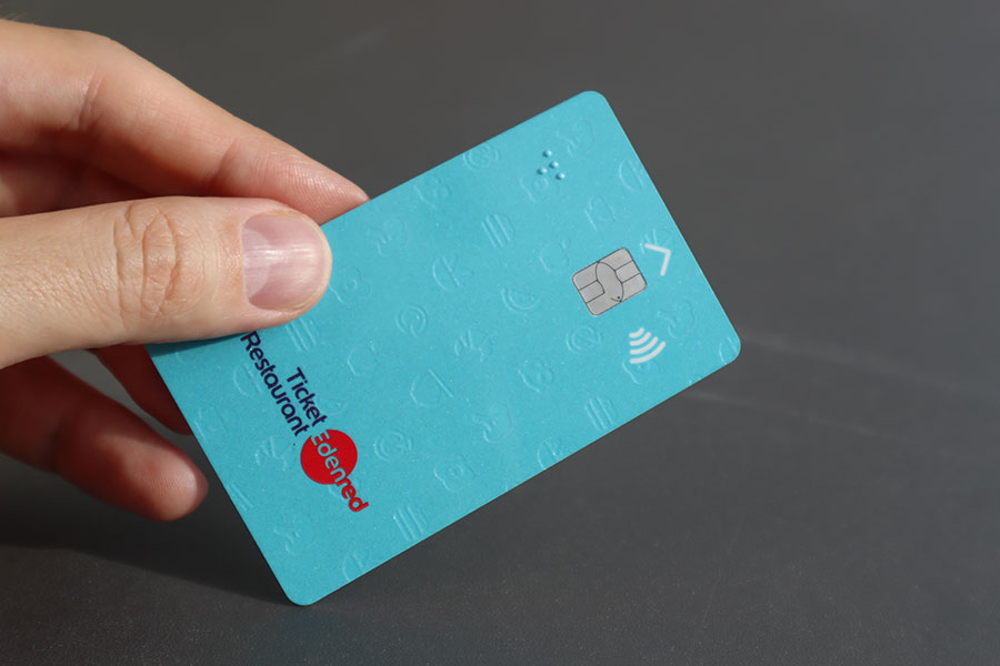 Main d'homme tenant une carte Edenred « ticket restaurant »