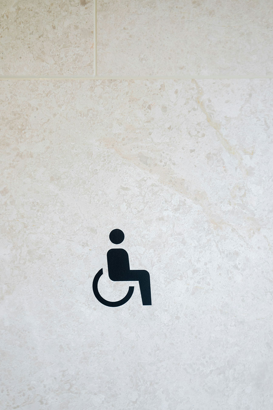 Pictogramme repr&eacute;sentant une personne assisse dans une chaise roulante