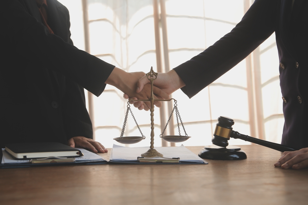 poignée de mains au dessus du symbole de la justice 